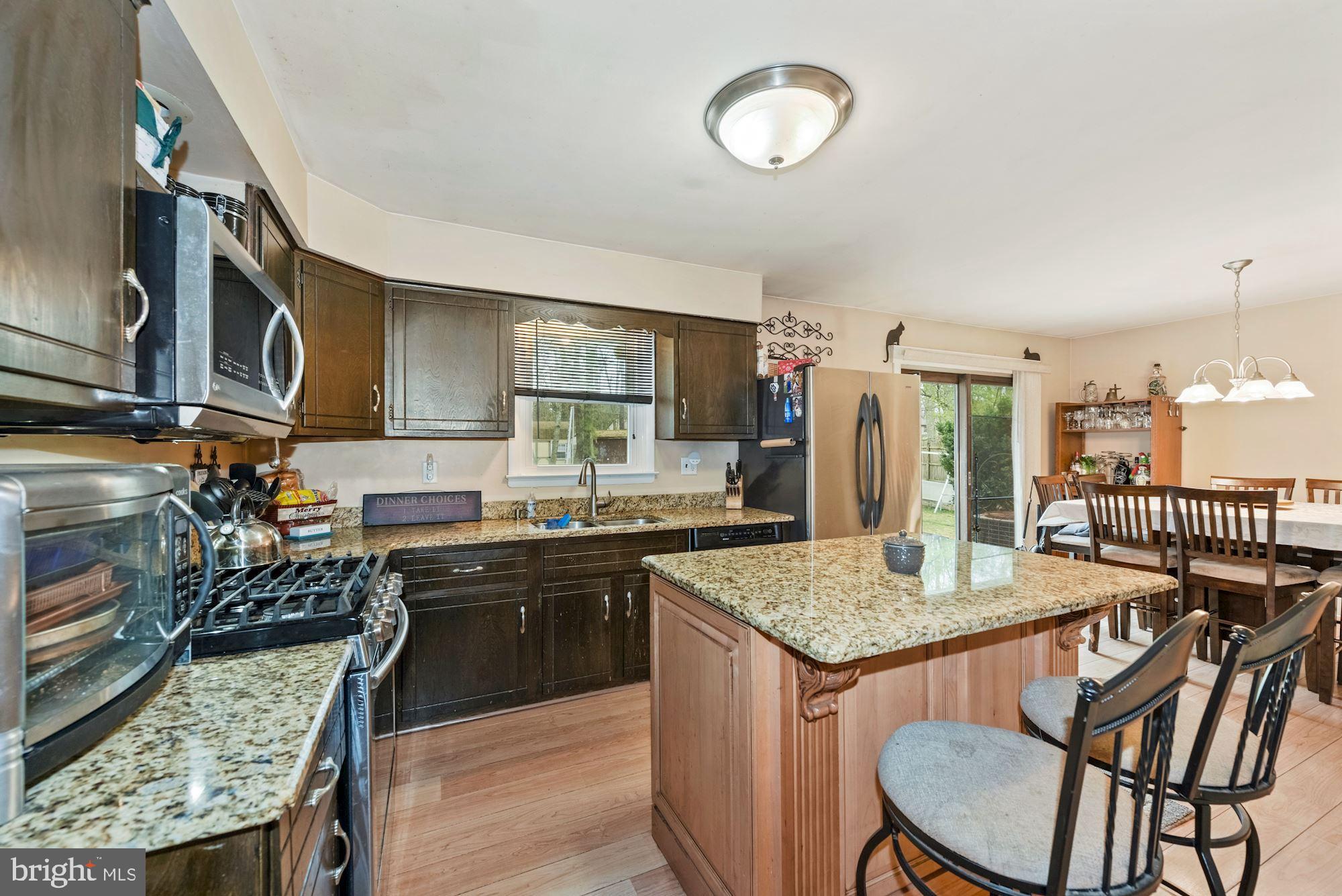 374 Holly Road Marlton, NJ 08053 - Photo 8 of 28 a kitchen with granite countertop a sink a stove a oven a dining table and chairs