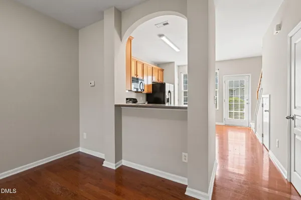 a view of a hallway with wooden floor and a bathroom