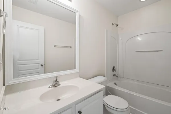 a bathroom with a toilet a sink a mirror and bathtub