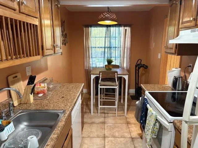 a kitchen with stainless steel appliances granite countertop a sink and a stove