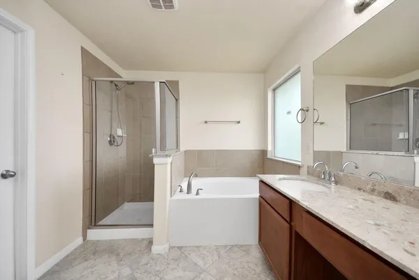 a bathroom with a granite countertop sink a mirror and a bathtub