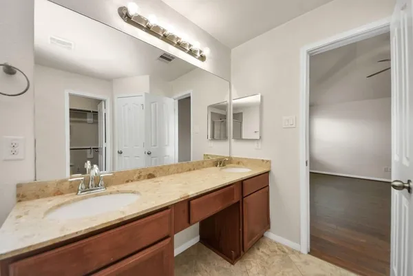 a bathroom with a granite countertop sink and a mirror