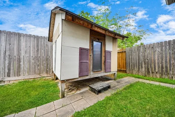 a backyard of a house with grass and wooden fence