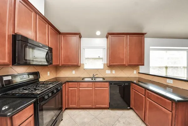 a kitchen with a sink stove top oven and cabinets