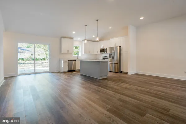 a kitchen with stainless steel appliances wooden floors and large window