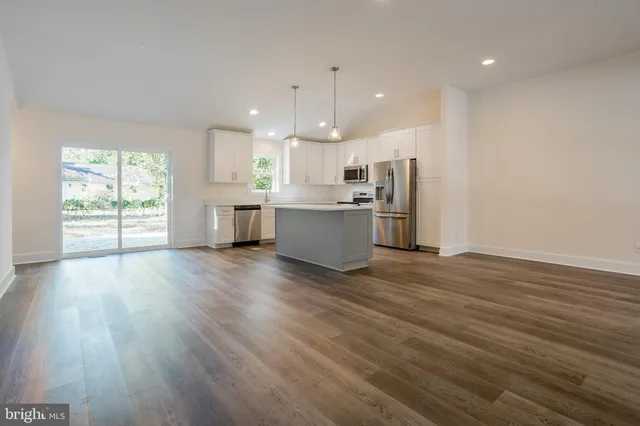 a kitchen with stainless steel appliances wooden floors and large window