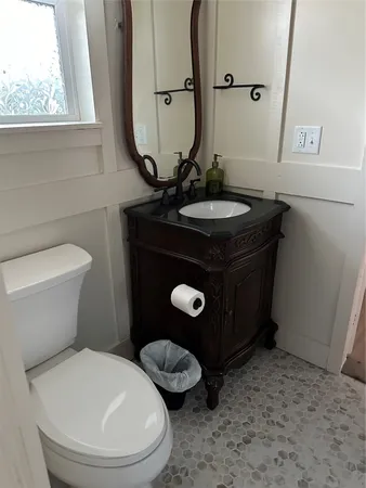 a bathroom with a toilet sink and mirror