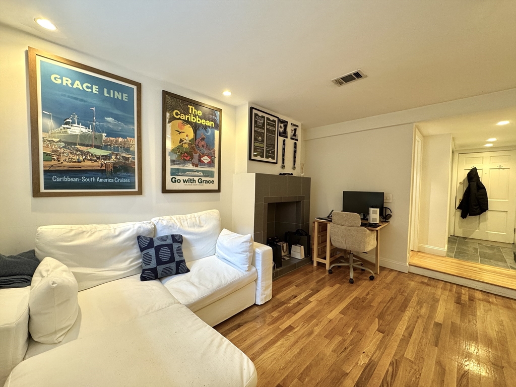 124 Beacon Street, Unit GF Boston, MA 02116 - Photo 2 of 11 a living room with furniture a fireplace and a flat screen tv