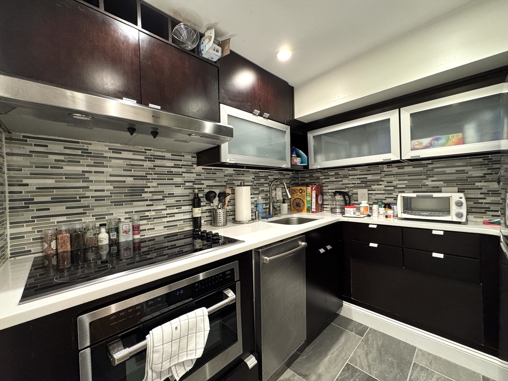 124 Beacon Street, Unit GF Boston, MA 02116 - Photo 7 of 11 a kitchen with stainless steel appliances a sink and wooden cabinets