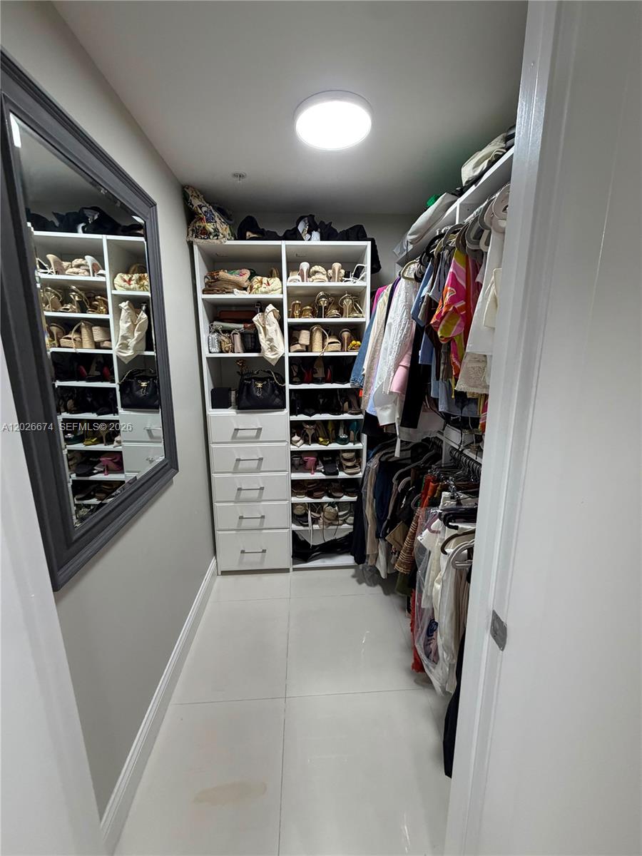90 Southwest 3rd Street, Unit 4006 Miami, FL 33130 - Photo 12 of 19 a view of walk in closet with clothes and shoes