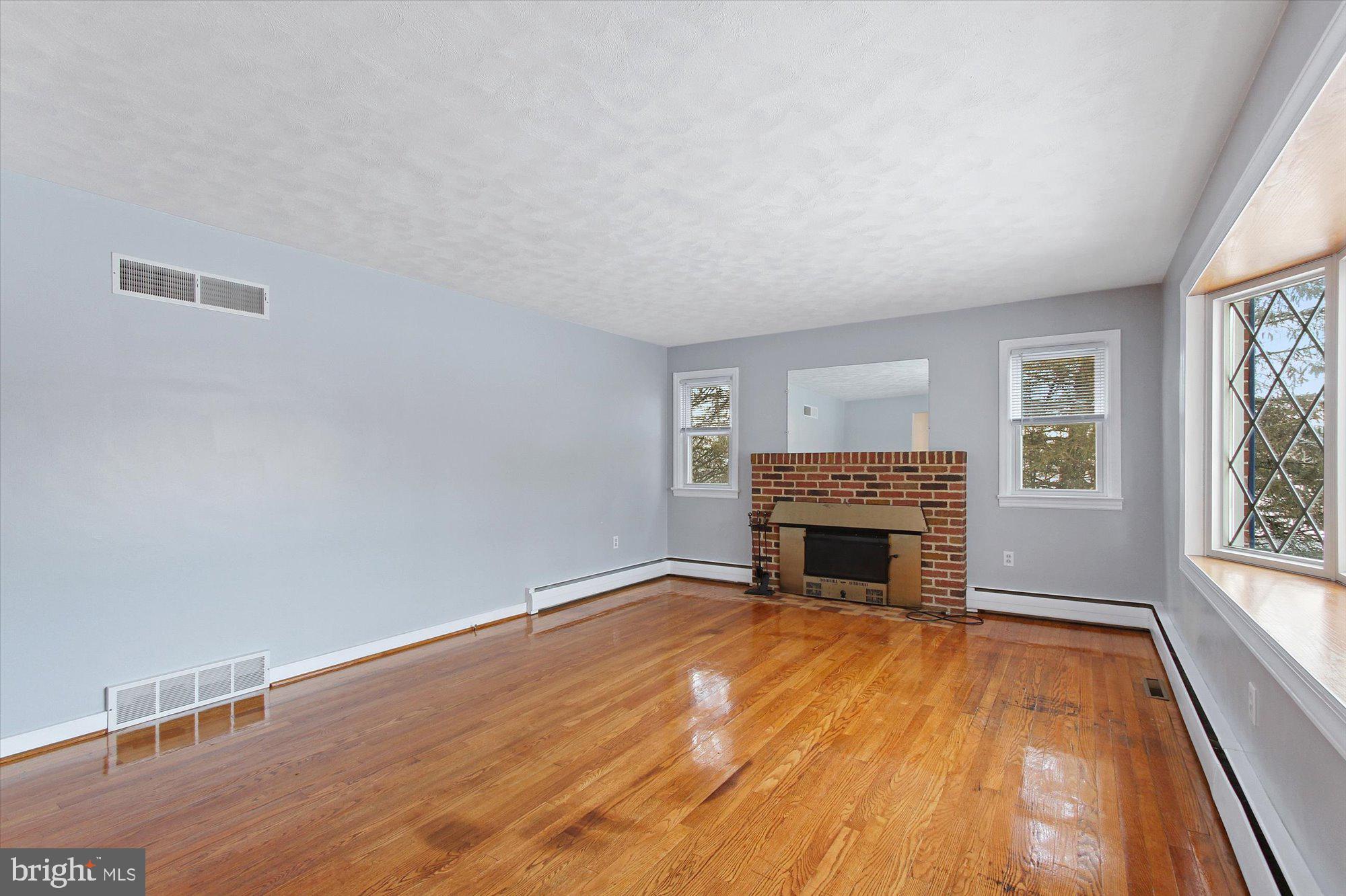 222 Dew Drop Road York, PA 17402 - Photo 3 of 31 wooden floor fireplace and windows in an empty room
