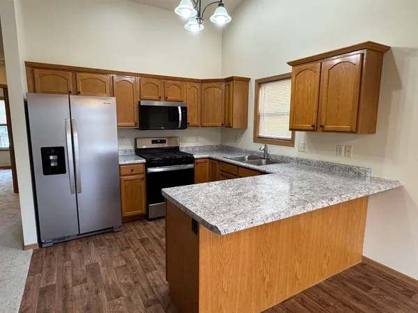 a kitchen with stainless steel appliances granite countertop a sink refrigerator and microwave