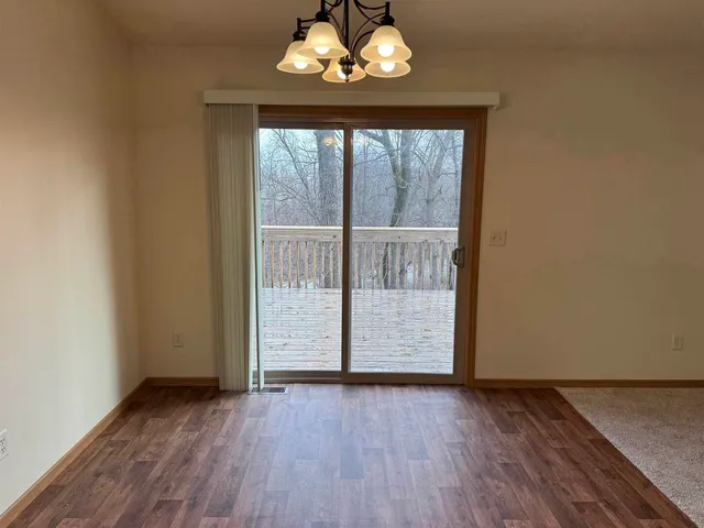 an empty room with wooden floor and chandelier