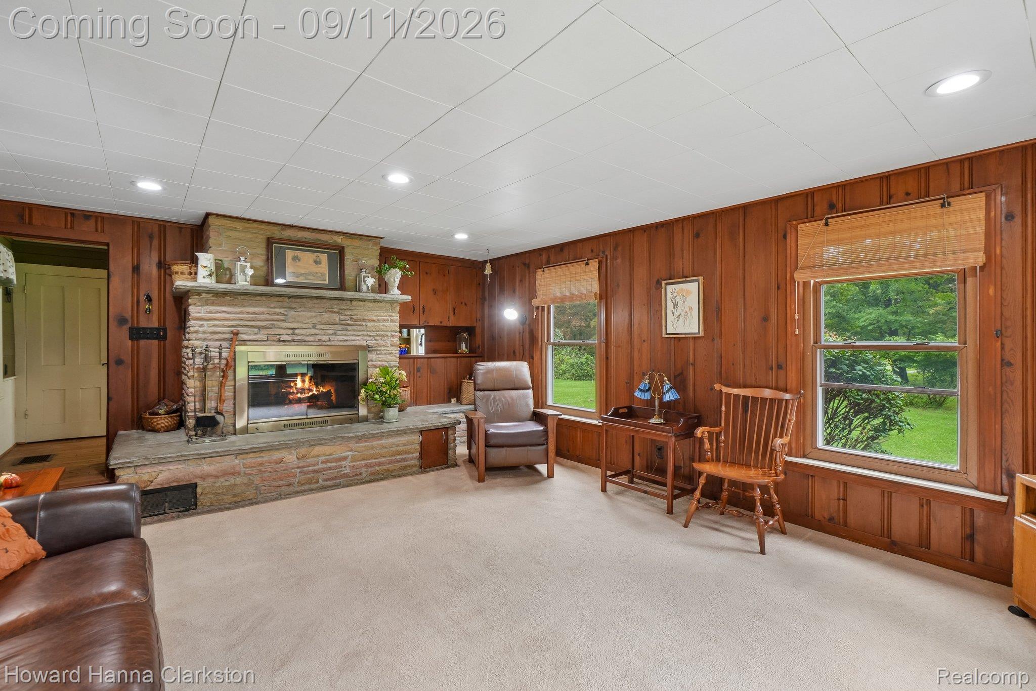8301 Foster Road Clarkston, MI 48346 - Photo 10 of 41 Stone-clad fireplace with a hearth, knotty pine paneling, and recessed lighting.