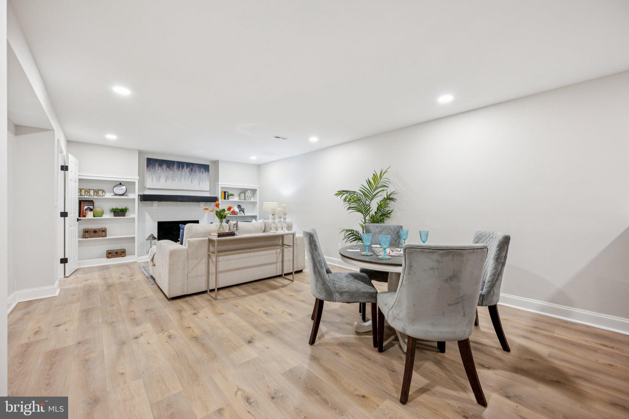 5144 Westpath Way Bethesda, MD 20816 - Photo 31 of 42 a living room with furniture a fireplace and a dining table with wooden floor