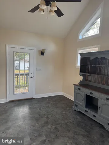 an empty room with windows and ceiling fan
