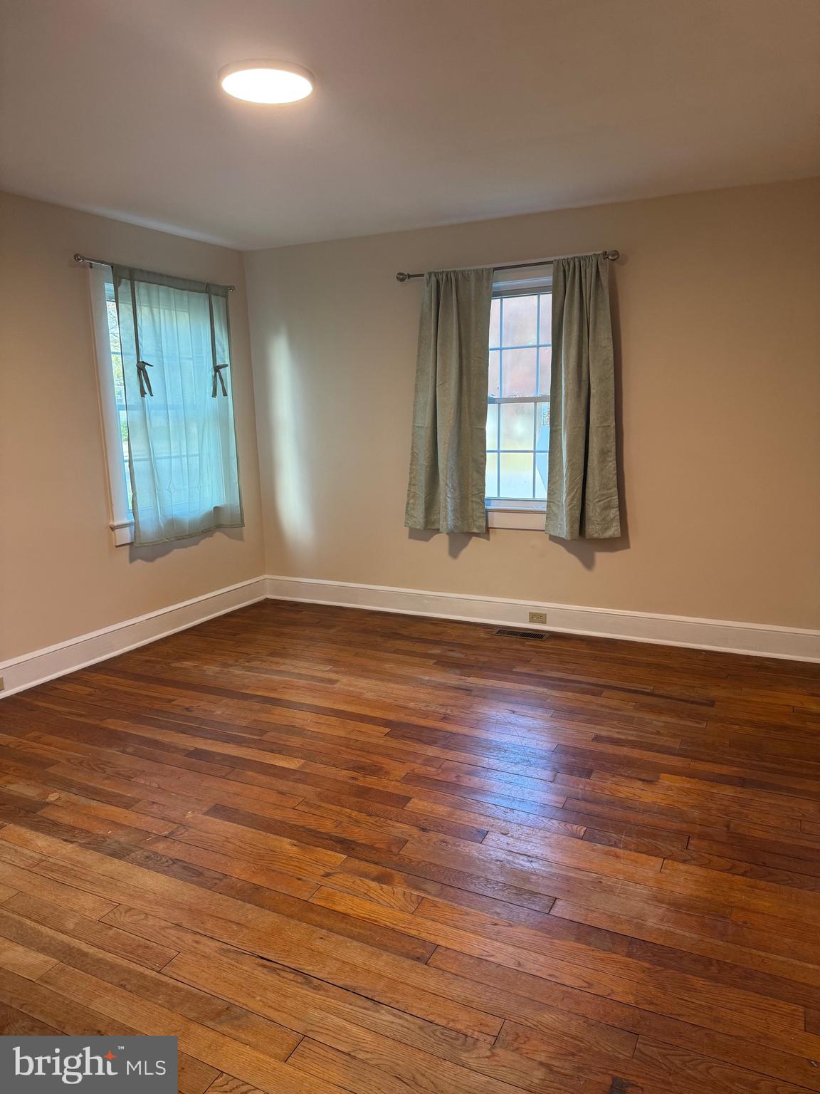 902 Cedar Street Pocomoke City, MD 21851 - Photo 16 of 27 an empty room with wooden floor and windows