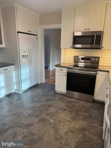 a view of kitchen with granite countertop cabinets and steel stainless steel appliances