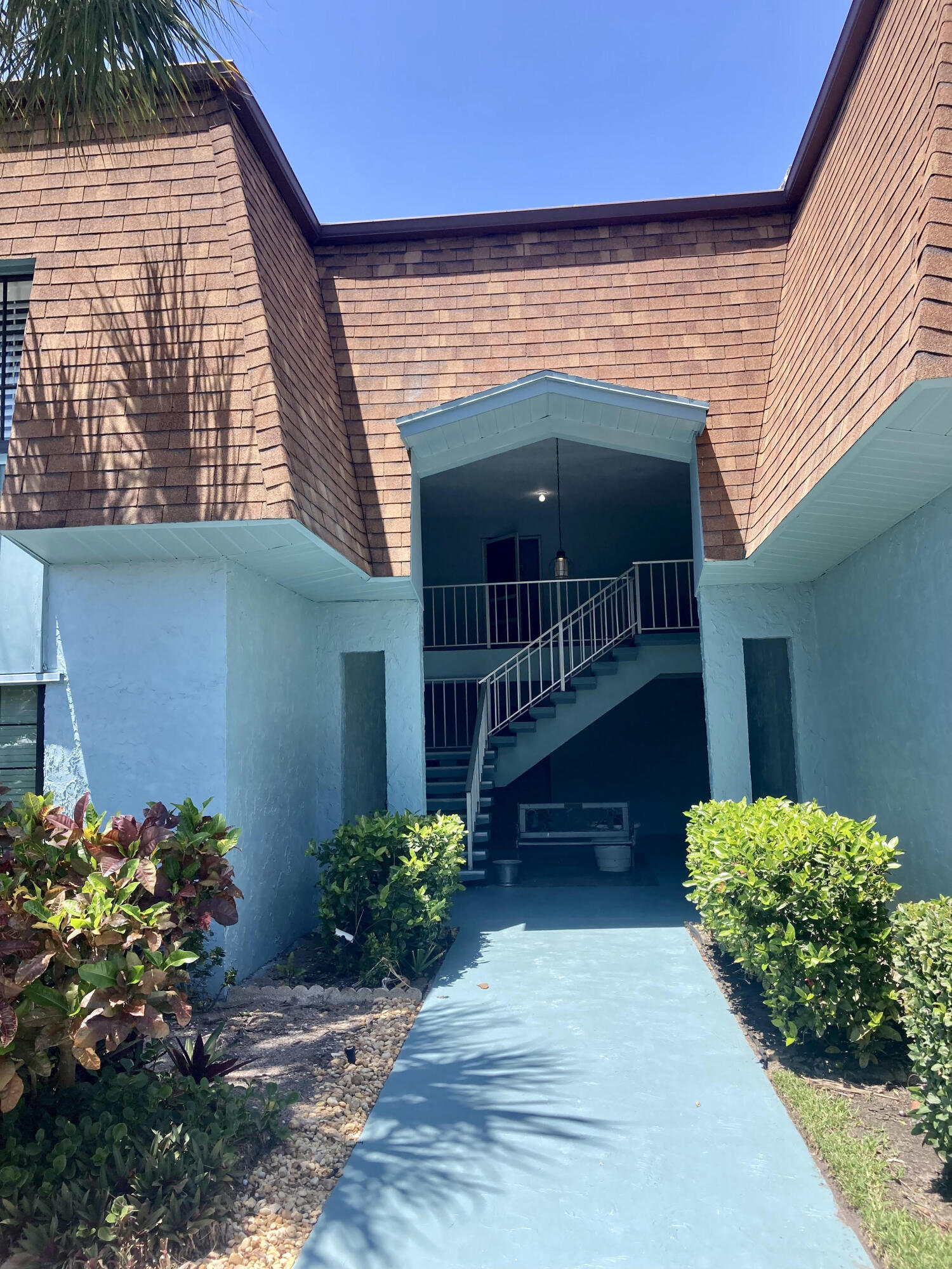 a view of a house with large windows and flower plants