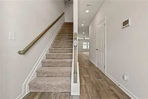 an empty room with windows and ceiling fan