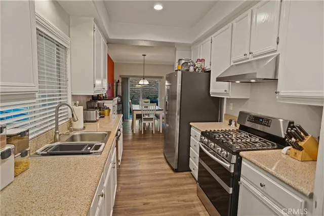 a kitchen with stainless steel appliances granite countertop a sink stove and refrigerator