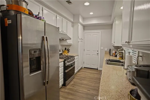 a kitchen with stainless steel appliances granite countertop a refrigerator and a stove