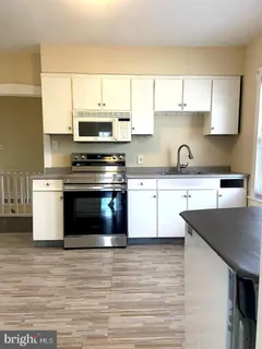 a kitchen with a stove a sink and a microwave