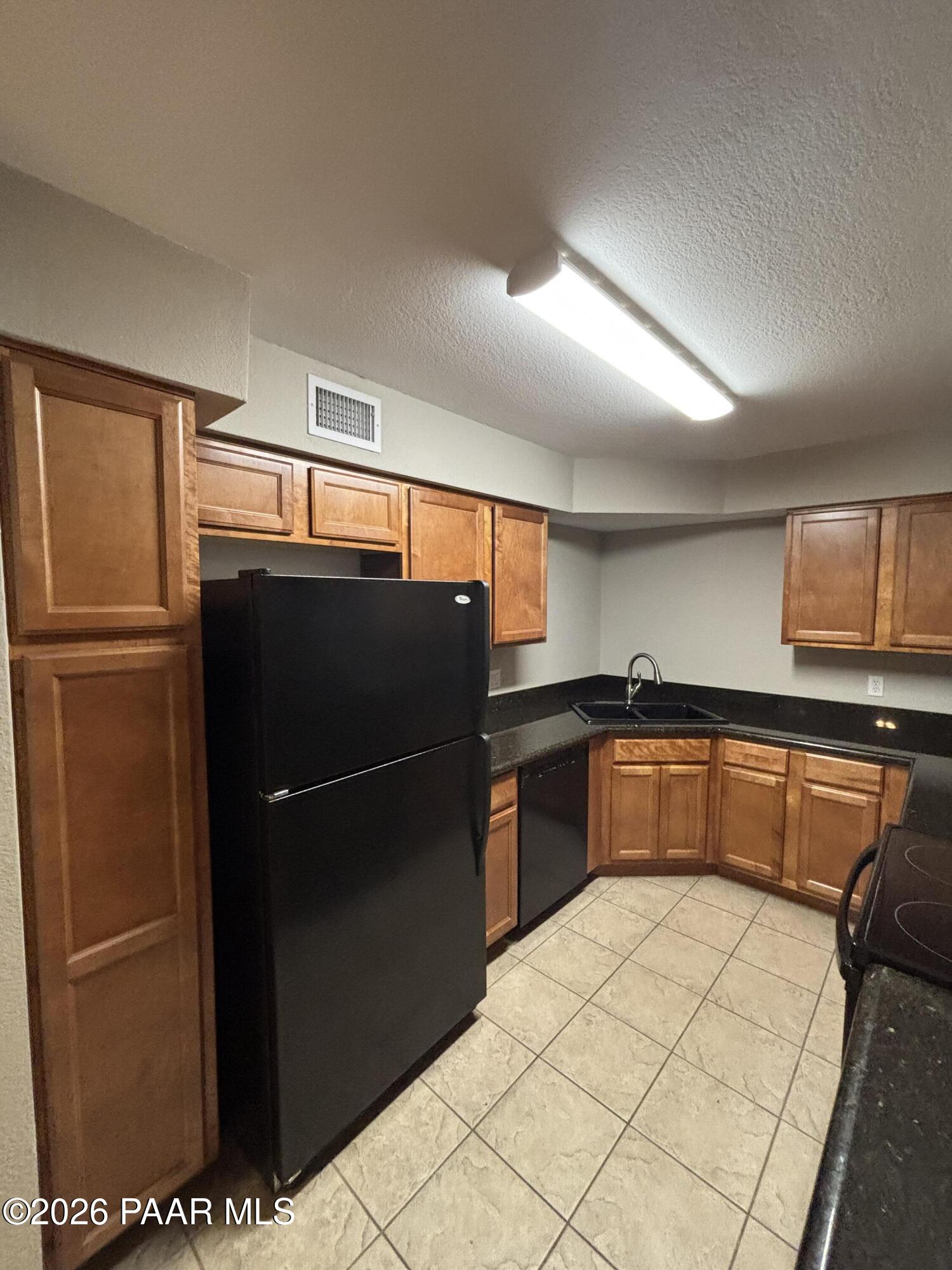 8787 East Mountain View Road, Unit 1082 Scottsdale, AZ 85258 - Photo 11 of 46 a kitchen with stainless steel appliances kitchen island granite countertop a refrigerator and a sink