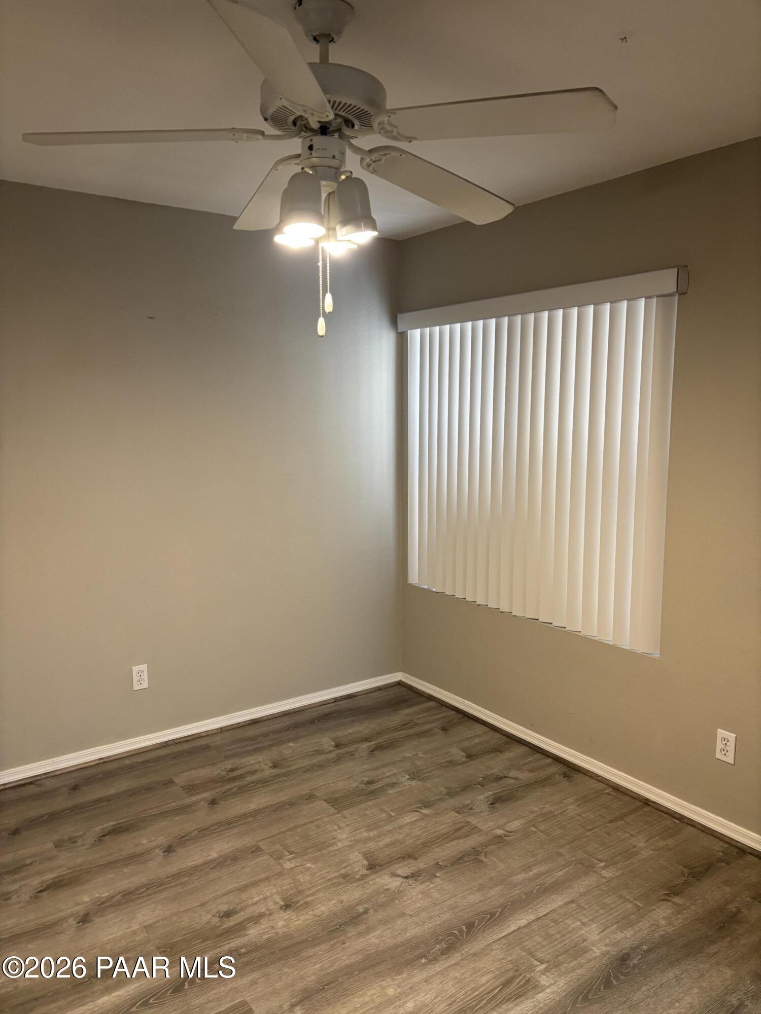 8787 East Mountain View Road, Unit 1082 Scottsdale, AZ 85258 - Photo 12 of 46 an empty room with wooden floor chandelier fan and windows