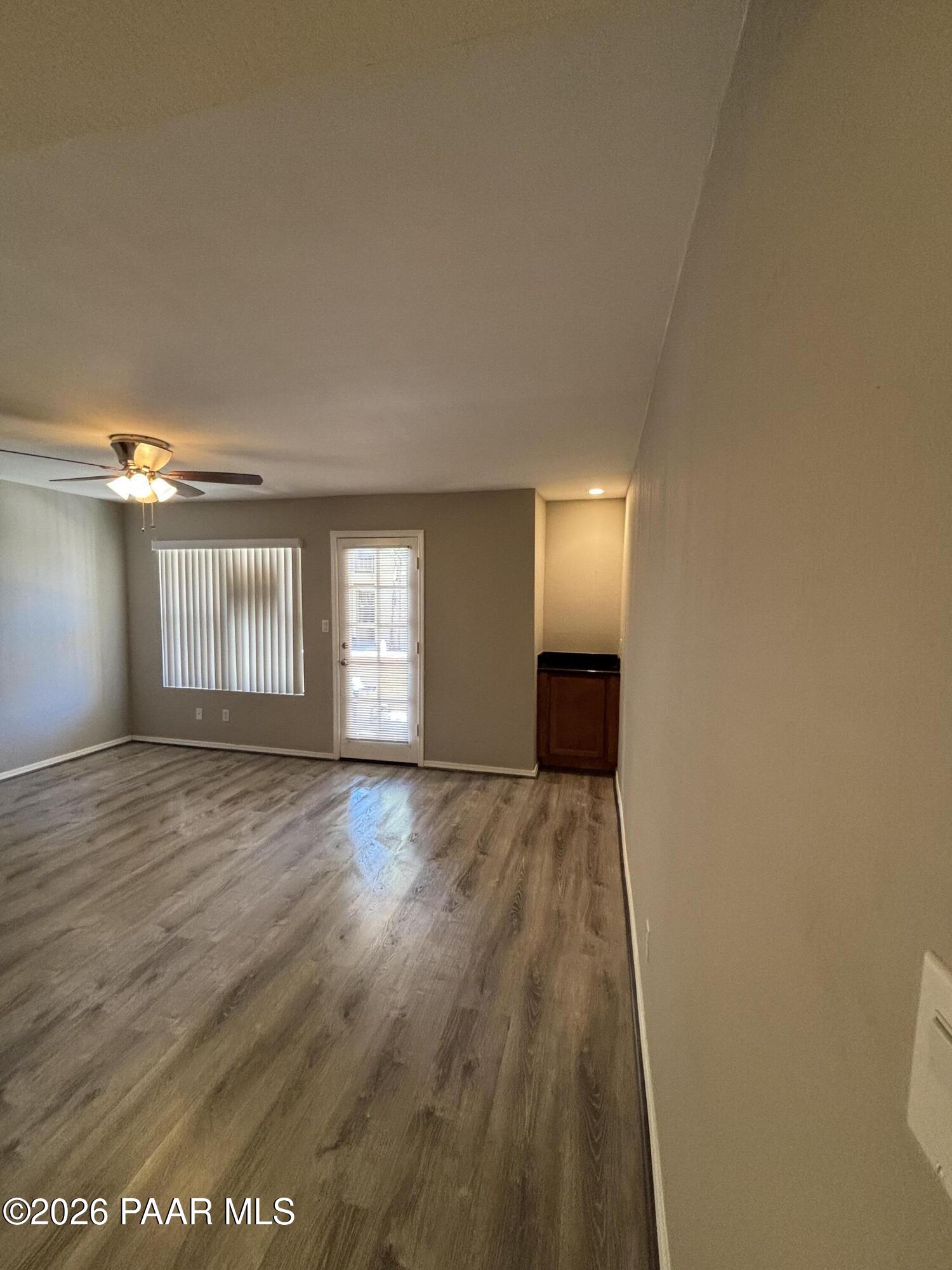 8787 East Mountain View Road, Unit 1082 Scottsdale, AZ 85258 - Photo 17 of 46 a view of an empty room with wooden floor and a window
