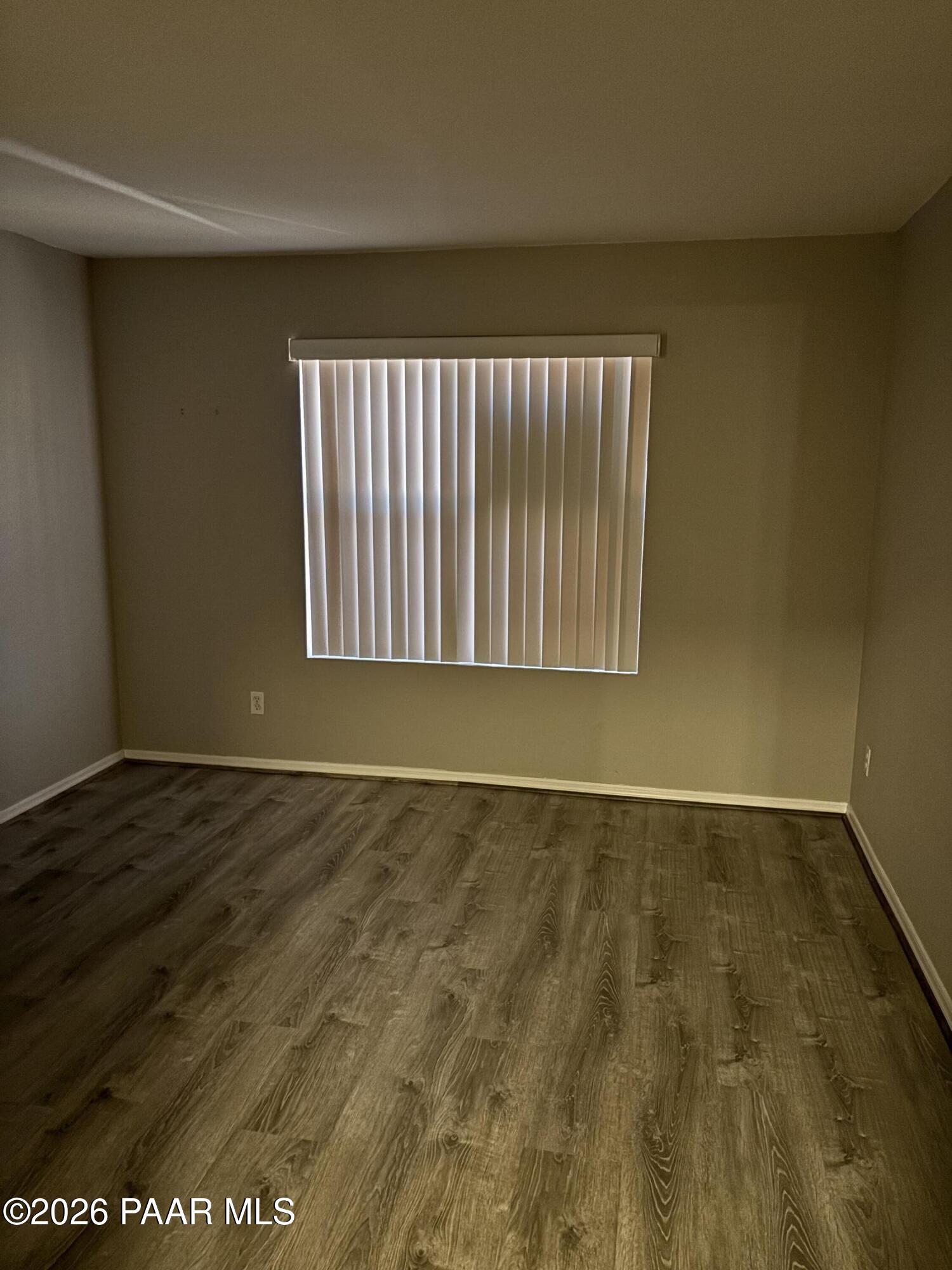 8787 East Mountain View Road, Unit 1082 Scottsdale, AZ 85258 - Photo 19 of 46 an empty room with wooden floor and windows