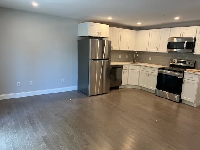 a kitchen with stainless steel appliances granite countertop a refrigerator stove a sink and a microwave