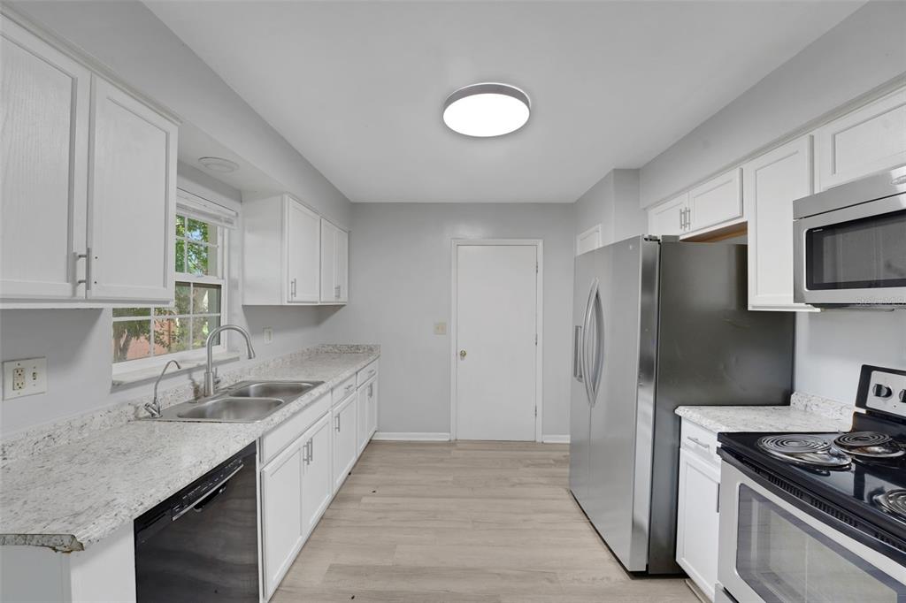 404 Lake Ned Road Winter Haven, FL 33884 - Photo 7 of 18 a kitchen with stainless steel appliances granite countertop a sink stove and refrigerator