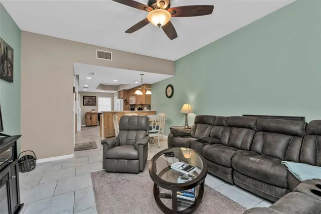 a living room with furniture and a ceiling fan