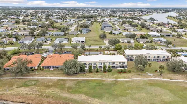 an aerial view of residential houses with yard and lake view