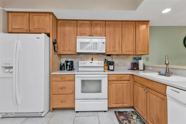 a kitchen with white cabinets and white appliances