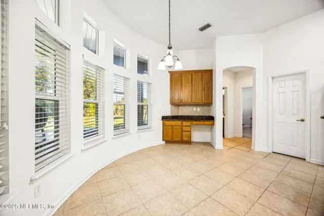 a bedroom with a bed and a flat tv screen on dresser