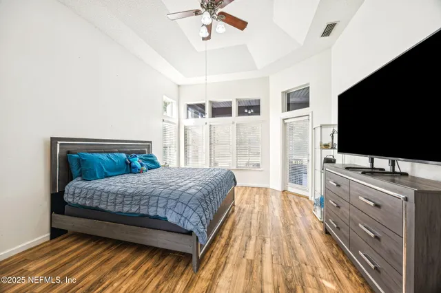 a bedroom with a bed and a flat tv screen on dresser
