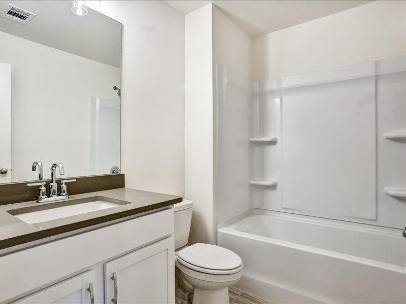 2539 Riverside Court Northeast Conyers, GA 30013 - Photo 16 of 31 a bathroom with a granite countertop sink a toilet and shower