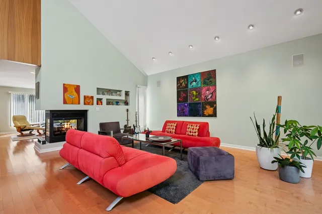 a living room with furniture kitchen view and a potted plant