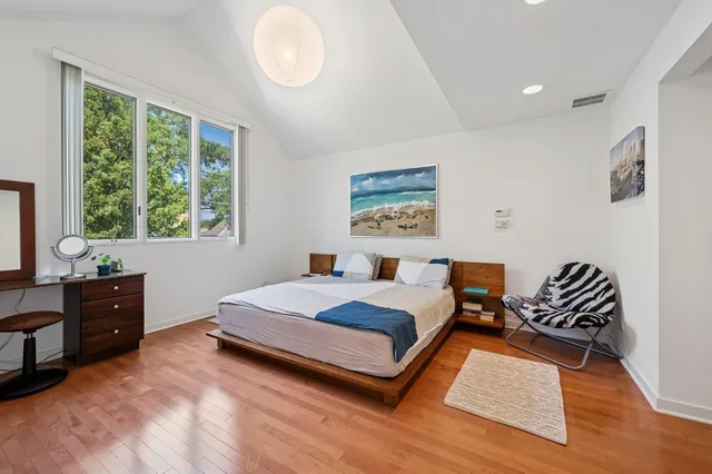 a bedroom with a bed and wooden floor