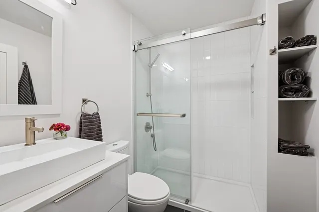 a bathroom with a shower a toilet and sink