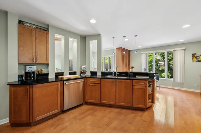 a large kitchen with granite countertop a large counter top space and stainless steel appliances