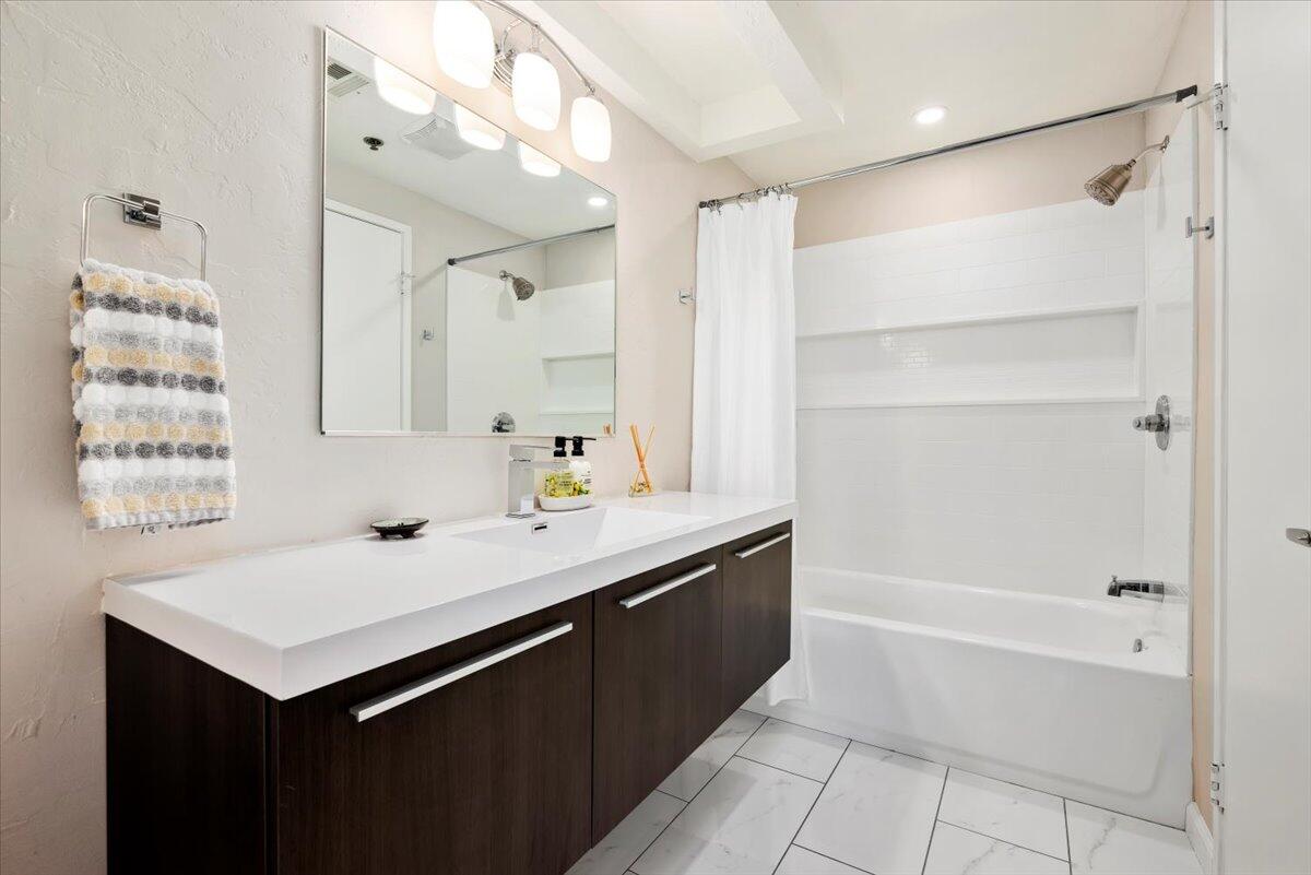 2700 Lawrence Crossley Road, Unit 10 Palm Springs, CA 92264 - Photo 13 of 15 a bathroom with a sink vanity granite tub shower and a mirror