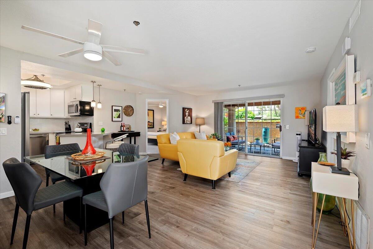 2700 Lawrence Crossley Road, Unit 10 Palm Springs, CA 92264 - Photo 3 of 15 a view of a dining room with furniture a rug and wooden floor