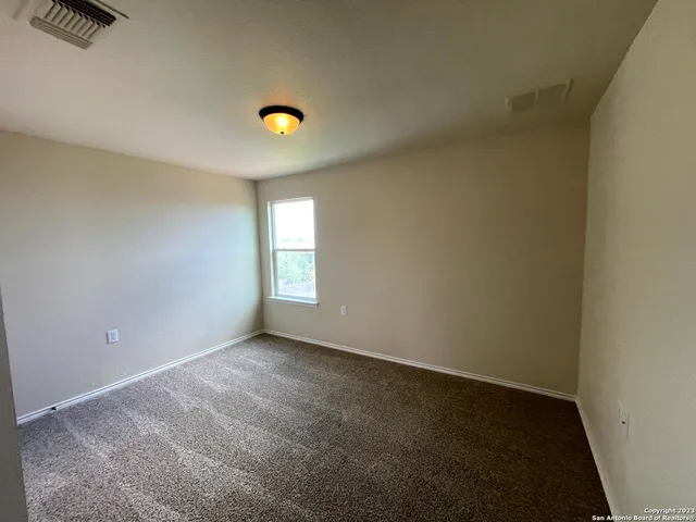 a view of a livingroom with an empty space and a window