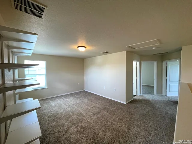 an empty room with windows and ceiling fan