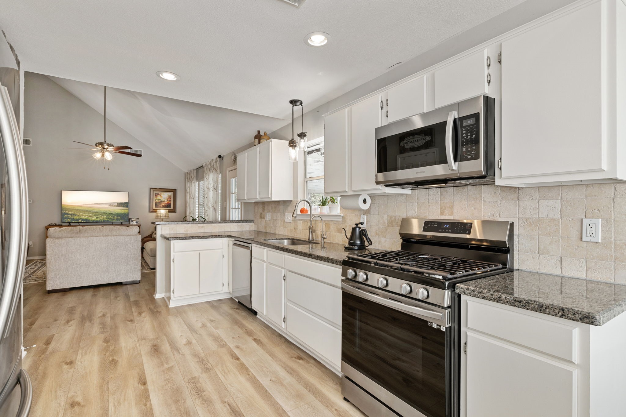 2106 Lexington Woods Drive Spring, TX 77373 - Photo 11 of 27 a kitchen with stainless steel appliances a stove microwave and sink