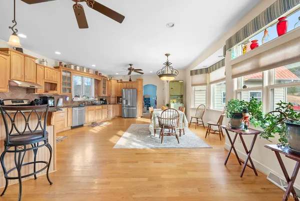a view of a dining room and livingroom with furniture wooden floor a chandelier