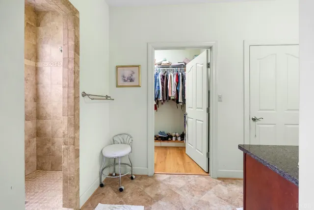 a bathroom with a granite countertop sink a mirror and a shower
